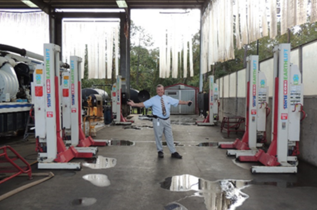 Bob Graden, Vac-Con plant manager standing with six Stertil-Koni EARTHLIFT mobile column lifts at the Green Cove Springs, FL plant.